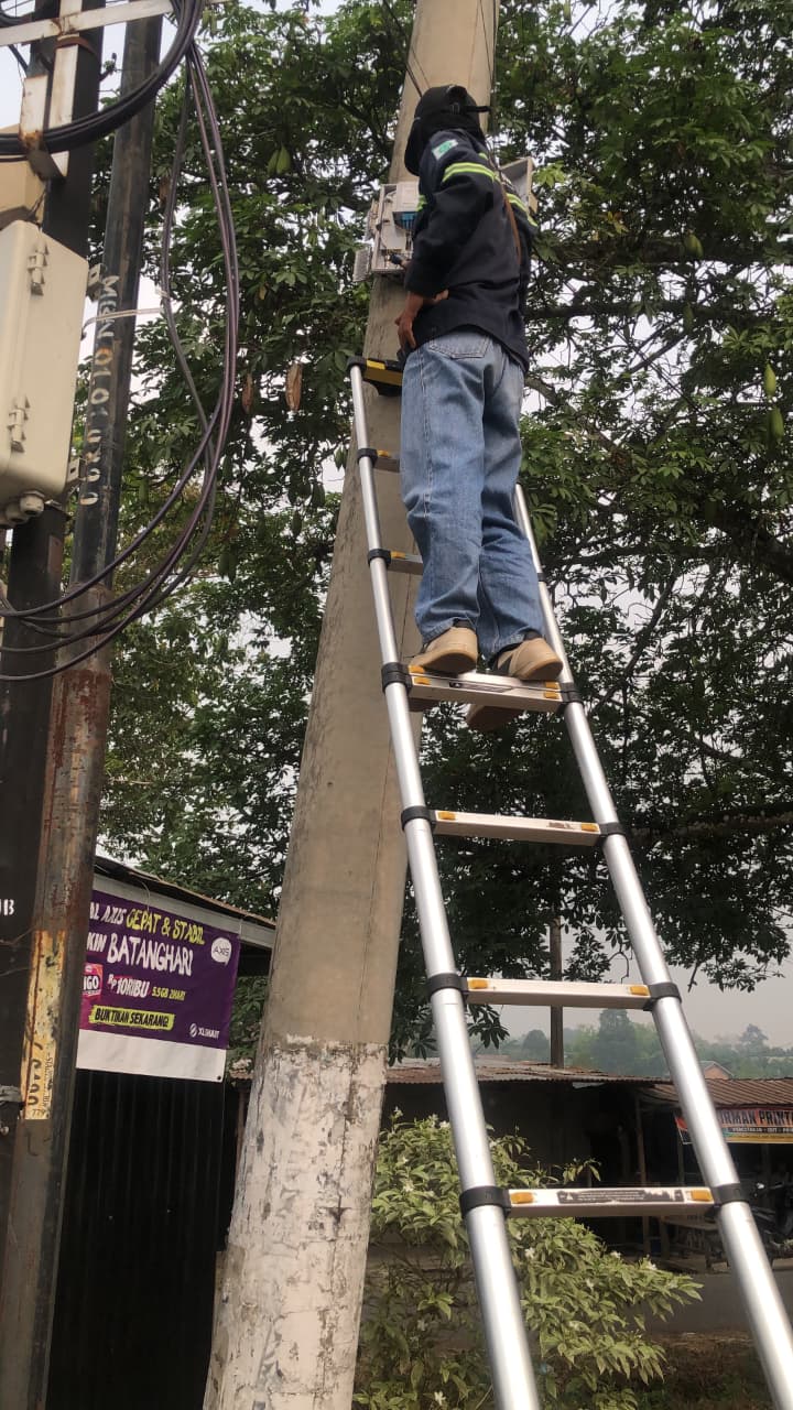 Teknisi memasang jaringan pada tiang telekomunikasi