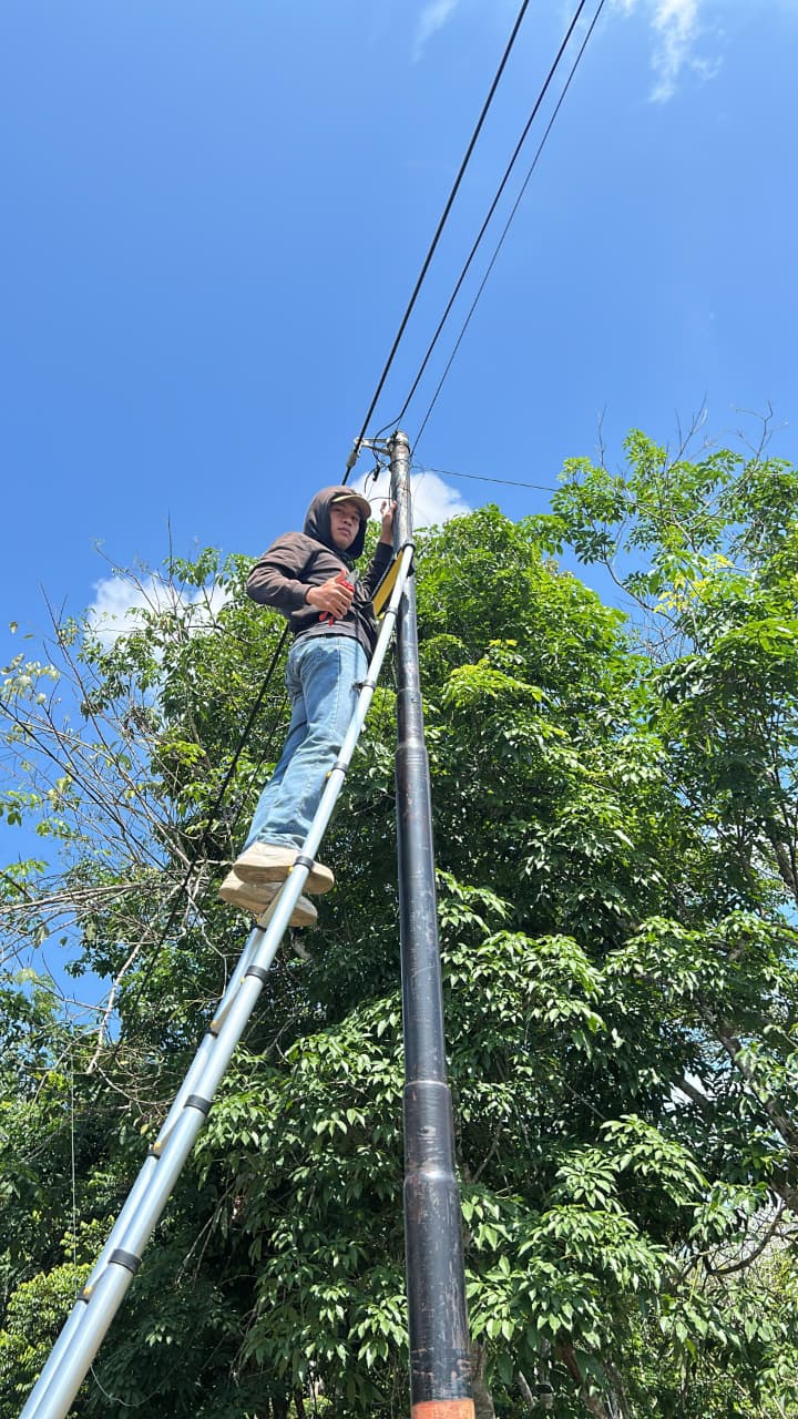 Teknisi Bulian Net bekerja pada jaringan di tiang saat siang hari